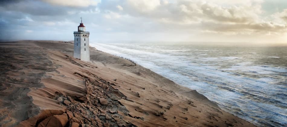 Lighthouse on Windswept Dunes by Jörg Hubrich — canvas wall art