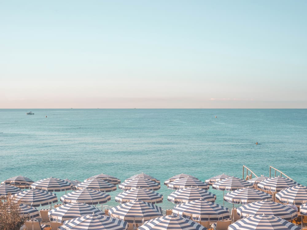 Striped Umbrellas Blue Sea by Talitha McQueen — canvas wall art